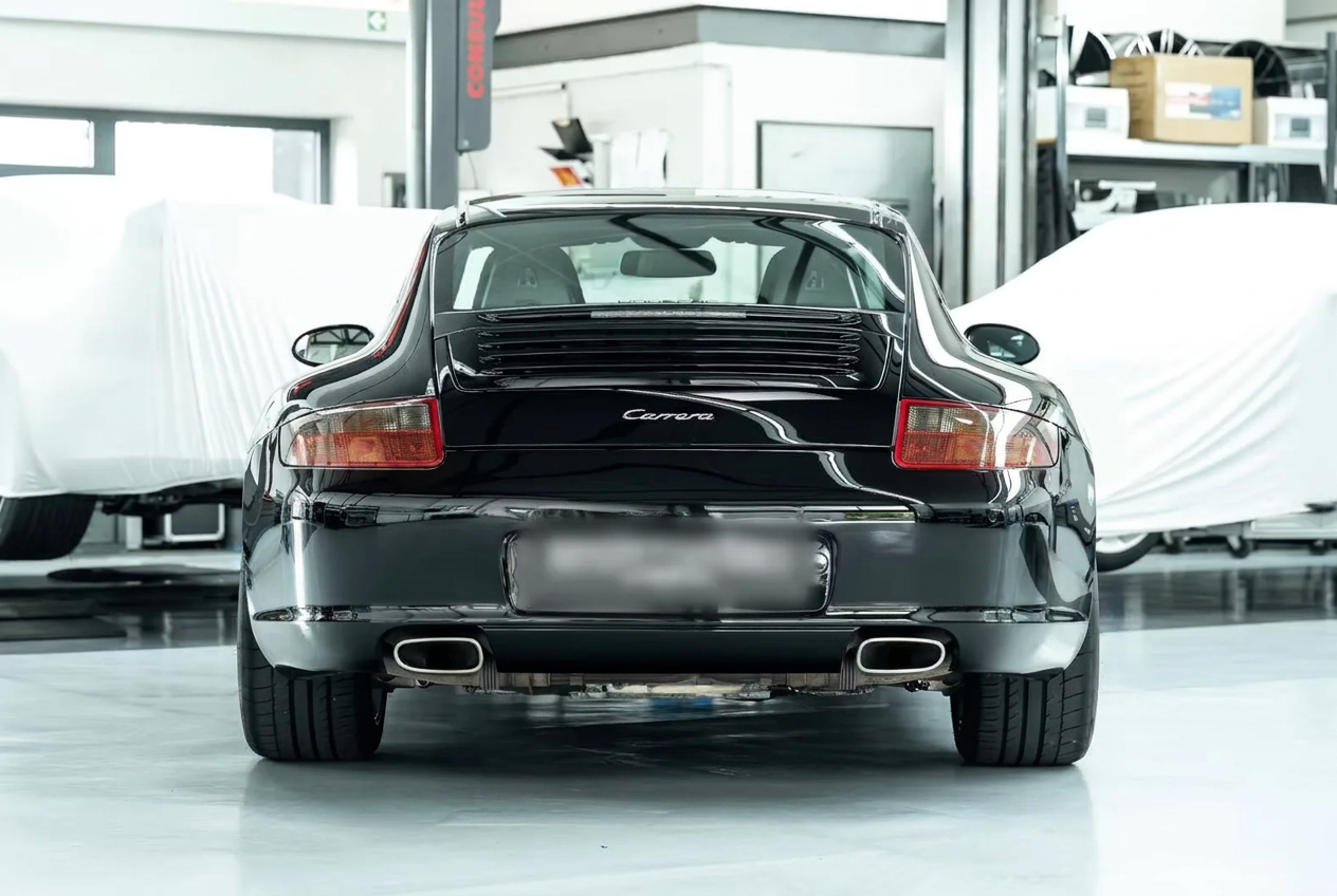 Rear view of a black Porsche 997 Carrera in a workshop