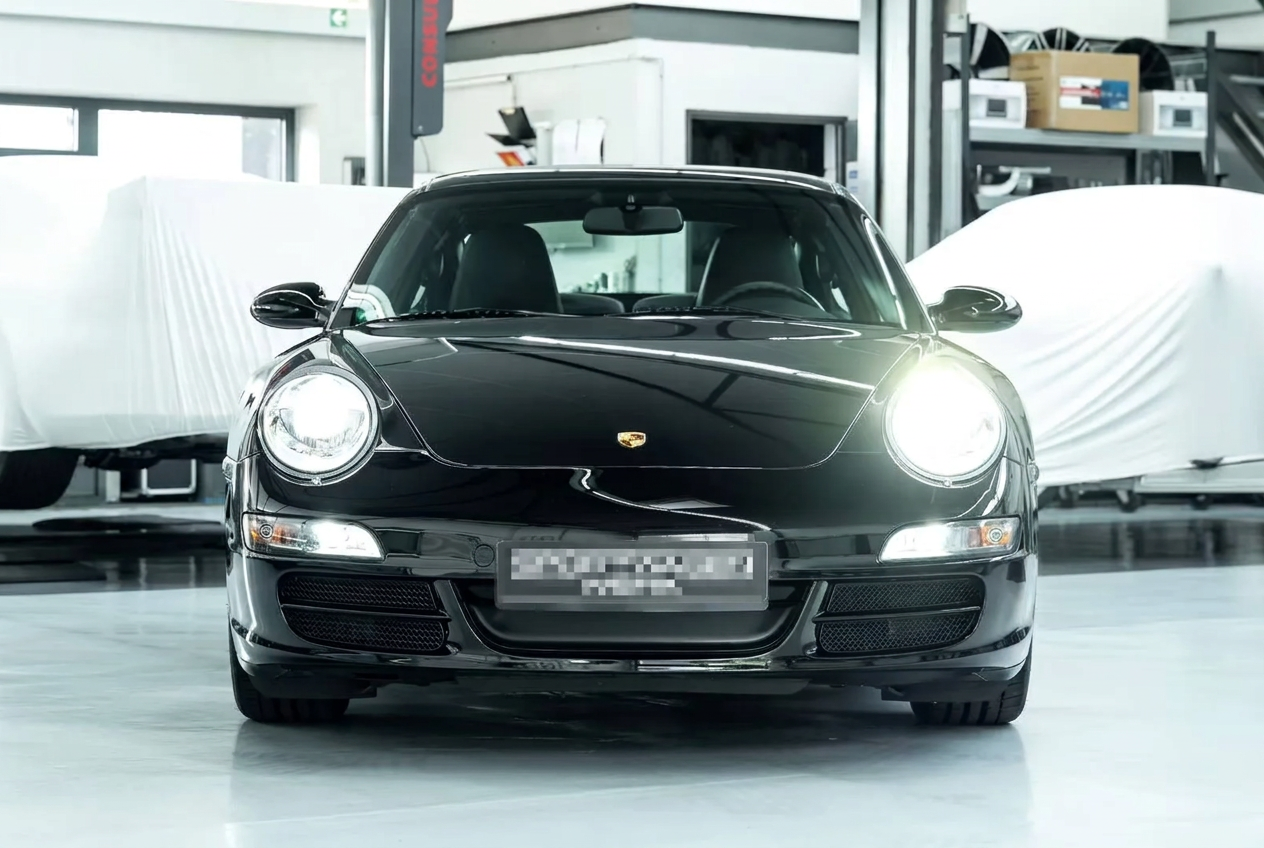 Front view of a black Porsche 997 Carrera in a workshop