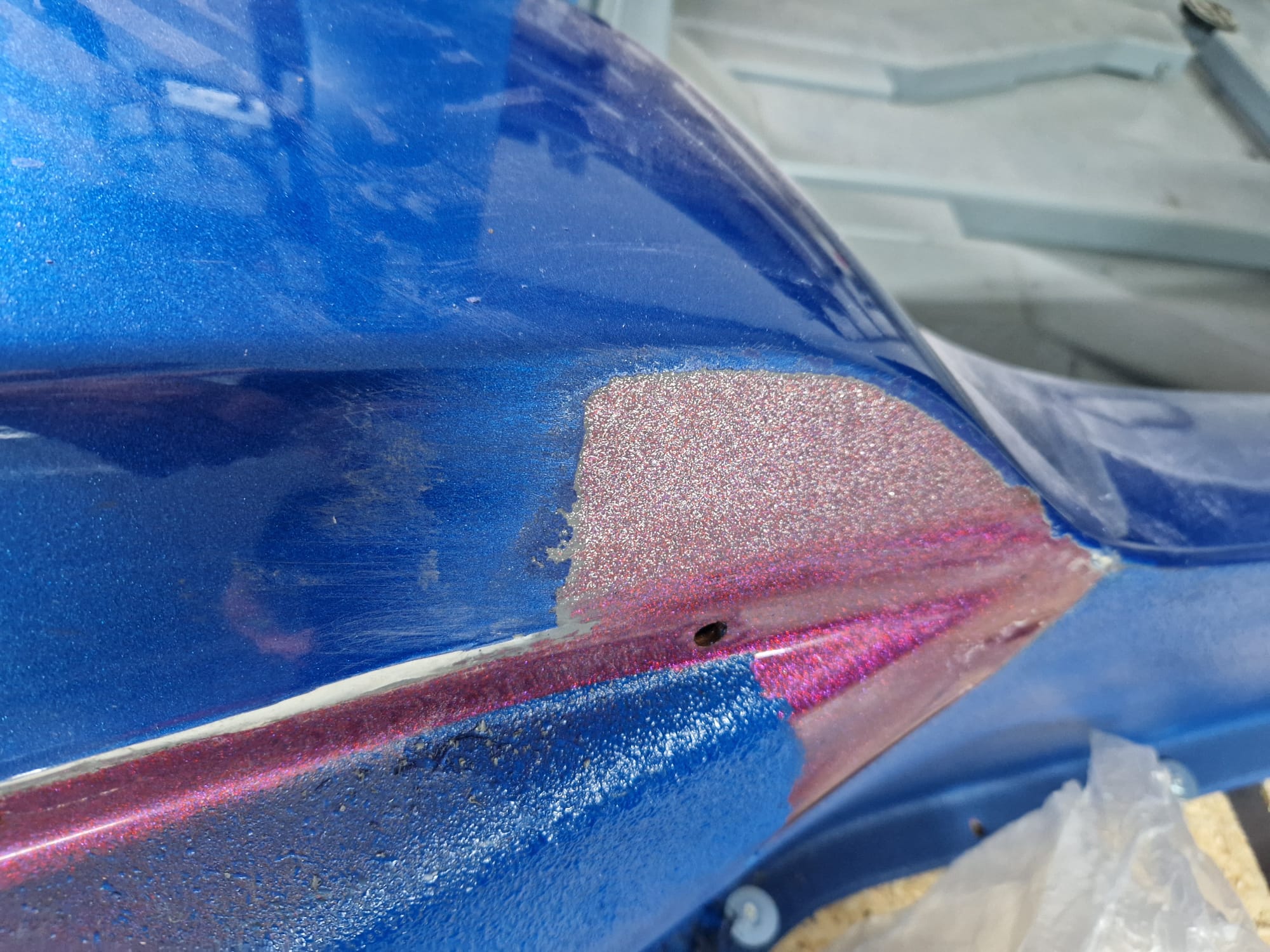 Originaler Gelcoat in Fuchsia Metallic unter blauem Lack an einem Meyers Manx